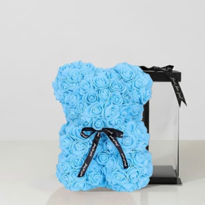 Blue rose-shaped teddy bear with a black ribbon and gift box