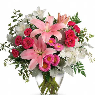 Pink lilies and roses arranged in a clear glass vase