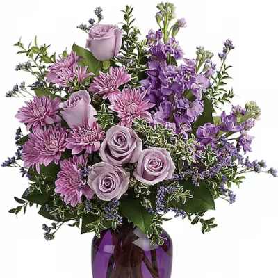 Lavender roses and purple flowers in a purple glass vase