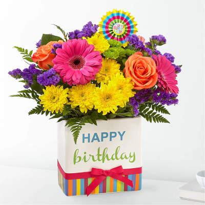 Bright mixed bouquet in a birthday gift box with a ribbon