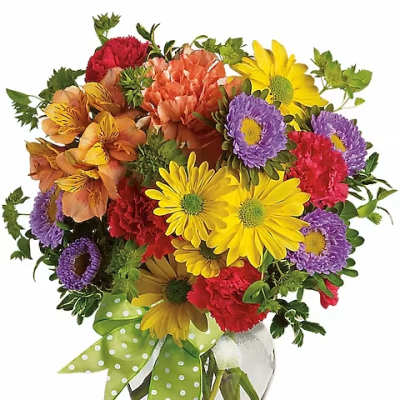 Colorful mixed bouquet in a clear glass vase with a green polka-dot ribbon
