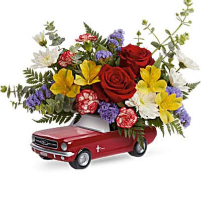 Bouquet of mixed flowers arranged in a red toy car