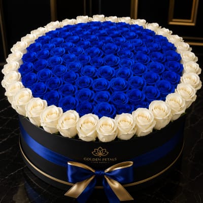 Round box of blue and white roses with a blue ribbon bow