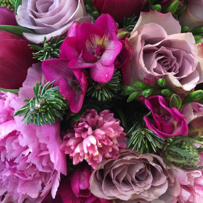 Close-up bouquet of pink and lavender roses with magenta blooms