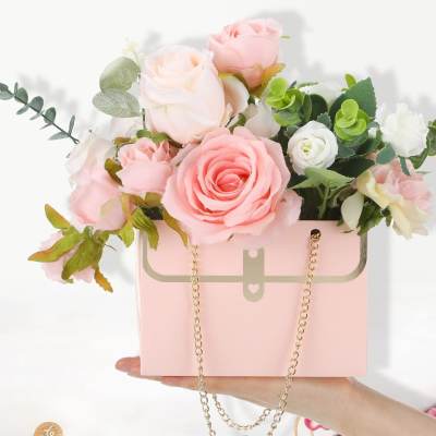 Pink and white roses arranged in a pink handbag-shaped box