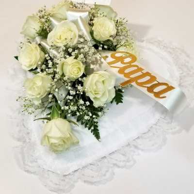 White rose bouquet with a satin ribbon on a lace-covered base