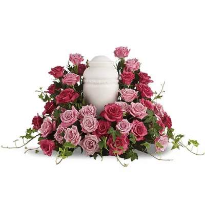Pink and red roses arranged around a white urn