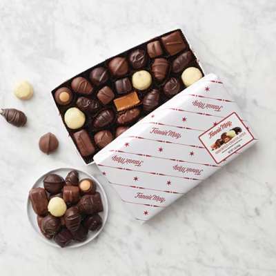 Box of assorted chocolates with a few pieces scattered beside it
