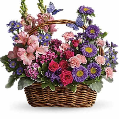 Basket arrangement of pink and purple flowers with butterfly accents