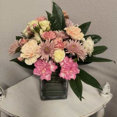 Pink and cream mixed bouquet in a square glass vase