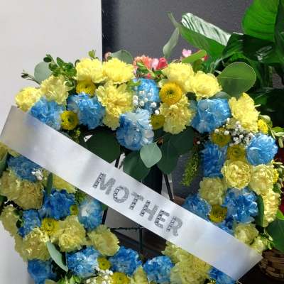 Heart-shaped floral wreath with a silver mother ribbon