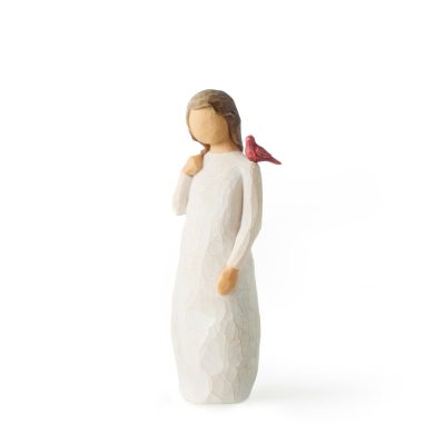Small carved figurine of a girl in a white dress with a red bird on her shoulder