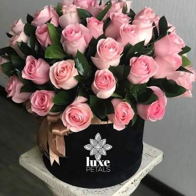 Bouquet of pink roses in a black hat box with a ribbon