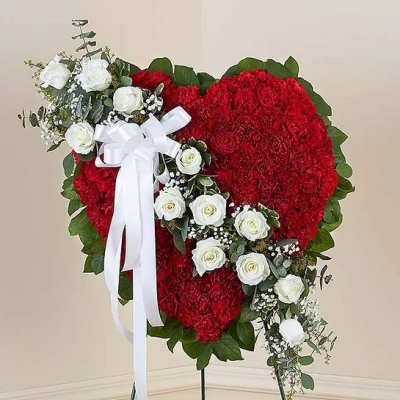 Heart-shaped red floral spray with white roses and a white ribbon