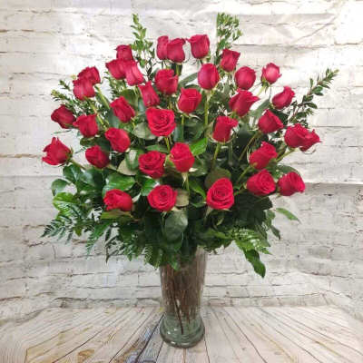 Tall bouquet of red roses in a clear glass vase