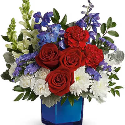 Red roses and white daisies in a blue glass vase
