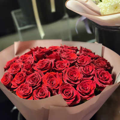 Bouquet of red roses wrapped in pale pink paper