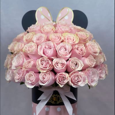 Pink roses arranged in a polka-dot hat box with a ribbon and bunny ears
