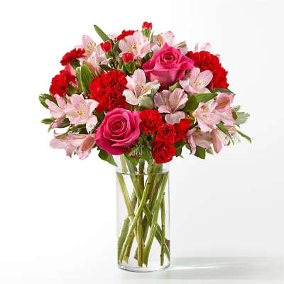 Pink roses and red carnations in a clear glass vase