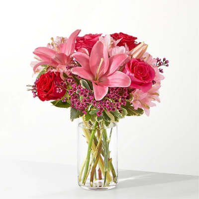 Pink lilies and red roses in a clear glass vase