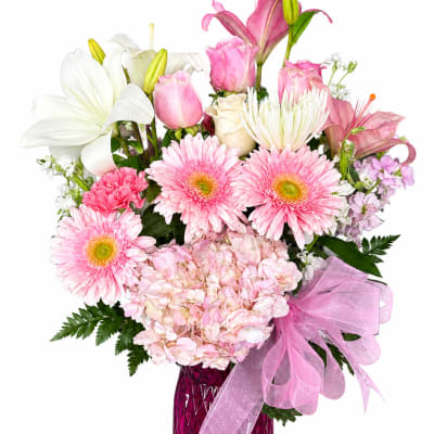 Pink and white mixed bouquet in a magenta vase with a pink ribbon