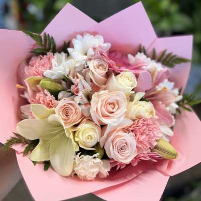 Pink and cream bouquet with roses, lilies, and carnations wrapped in pink paper