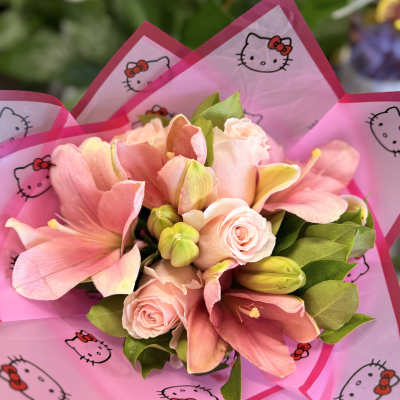 Pink bouquet with roses and lilies wrapped in Hello Kitty paper