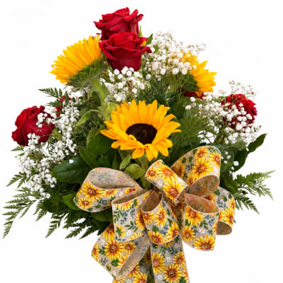 Bouquet of red roses and yellow sunflowers with white baby's breath in a glass vase