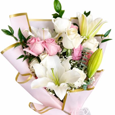 Pink and white bouquet with lilies and roses wrapped in pink paper