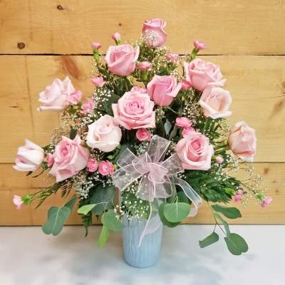 Pink rose bouquet in a light blue vase with a sheer ribbon