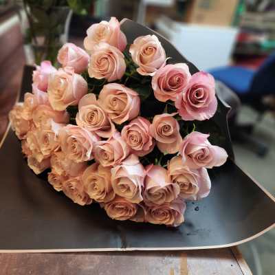 Bouquet of pale pink roses wrapped in black paper