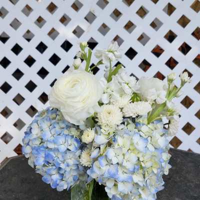 Blue and white flower arrangement in a glass vase