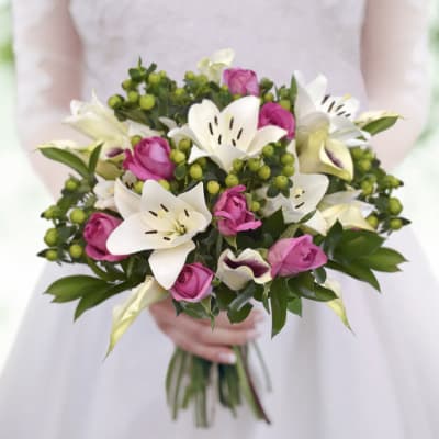 Bouquet of pink roses and white lilies with green berries