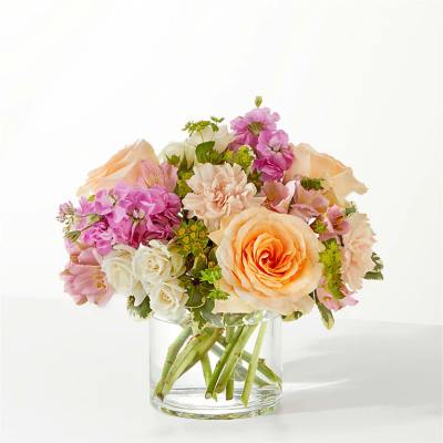 Bouquet of peach, pink, and white flowers in a clear glass vase