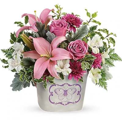 Pink lilies, roses, and white alstroemeria in a decorative container