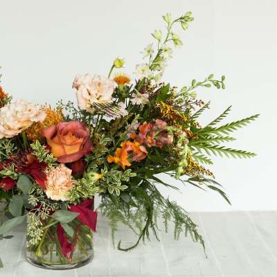 Mixed bouquet in a clear glass vase with roses and assorted blooms