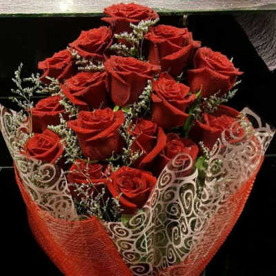Bouquet of red roses wrapped in decorative red and white paper