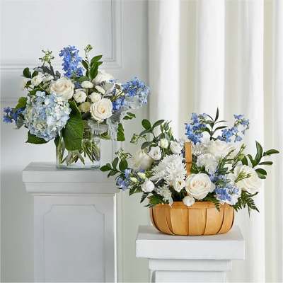 Two blue and white floral arrangements in a glass vase and wooden basket
