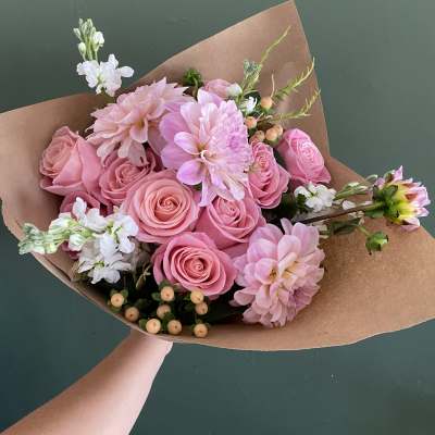 Pink rose and dahlia bouquet wrapped in brown paper