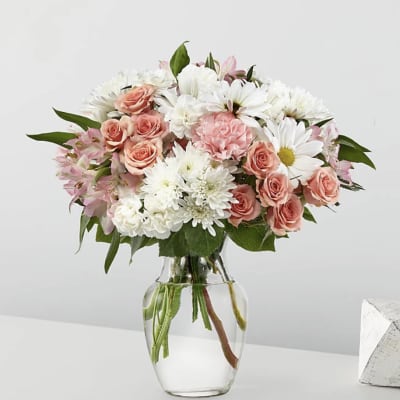 Pink roses and white daisies in a clear glass vase