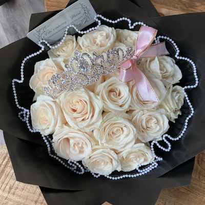 Bouquet of cream roses with a jeweled tiara and pink ribbon