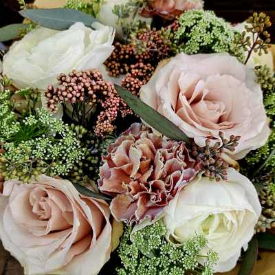 Close-up bouquet of blush roses, white blooms, and pink carnations