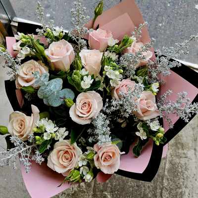 Bouquet of pale pink roses with white filler flowers and silver foliage