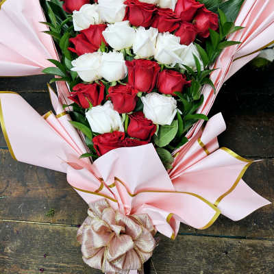 Bouquet of red and white roses wrapped in pink paper