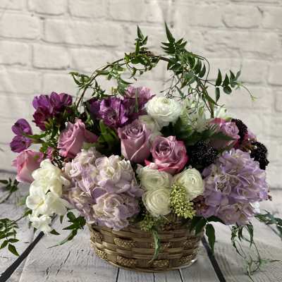 Basket arrangement of pink, white, and purple flowers