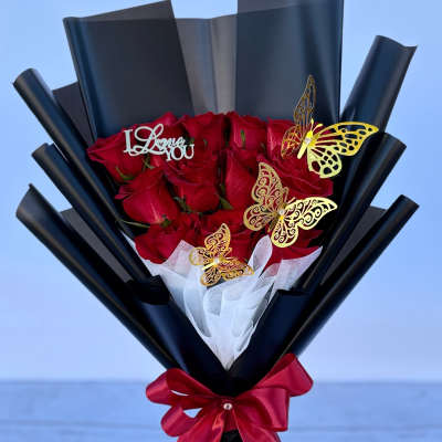Bouquet of red roses wrapped in black paper with a red ribbon