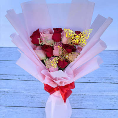 Pink and red rose bouquet with butterfly picks and a red ribbon