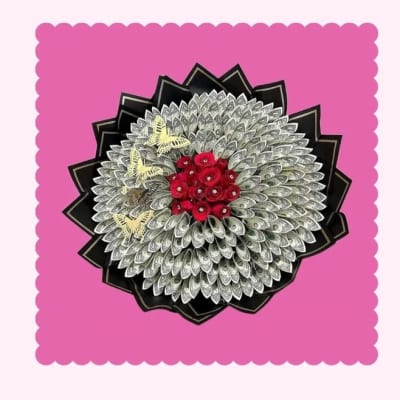 Decorative money bouquet with red roses on a pink background