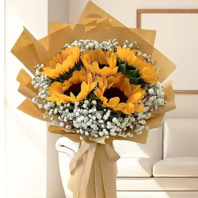 Bouquet of sunflowers wrapped in tan paper with white filler flowers