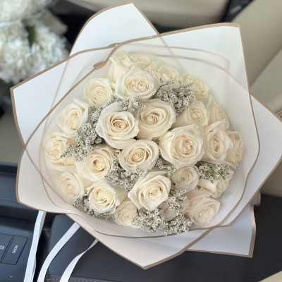 Bouquet of cream roses with small white filler flowers in white wrap